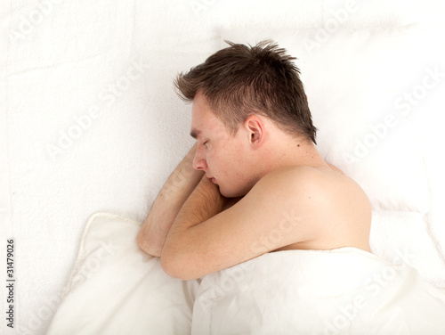 Photo: sleeping young handsome man in white bedding, series sleeping young handsome man in white bedding, series