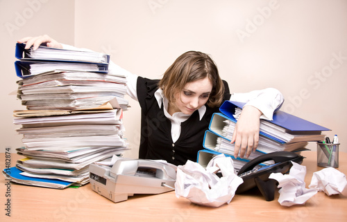 Photo: Young businesswoman with tons of documents Young businesswoman with tons of documents