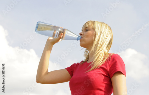 Foto: junge frau trinkt wasser aus einer flasche junge frau trinkt wasser aus einer flasche