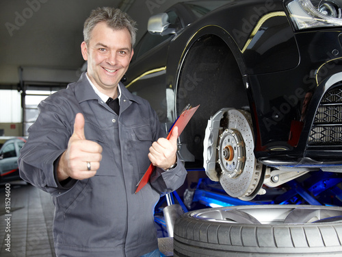 Foto: Master mechanic in a garage shows ok Master mechanic in a garage shows ok