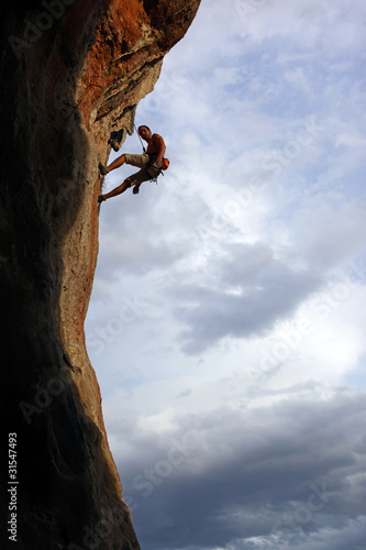 Photo: Silhouette of rock climber against cloudy sky Silhouette of rock climber against cloudy sky