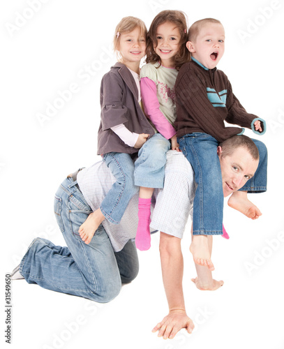 Photo: Happy kids playing riding on back of dad Happy kids playing riding on back of dad