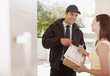 Woman signing box receipt for delivery man