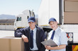 Workers standing with boxes near semi-truck