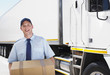 Worker carrying box near semi-truck
