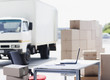 "Truck, boxes, desk and laptop in shipping area"