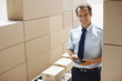 Foto: Worker standing with boxes in shipping area Worker standing with boxes in shipping area
