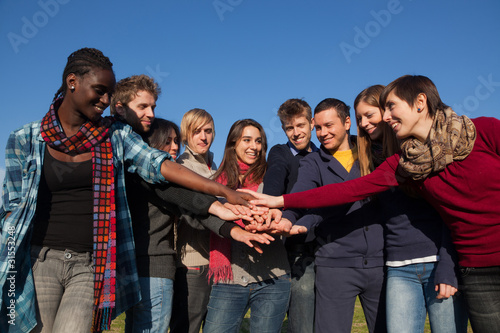 Photo: Happy College Students with Hands on Stack Happy College Students with Hands on Stack