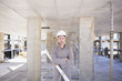 Construction worker holding blueprint on construction site