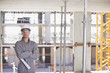 Construction worker holding blueprints on construction site