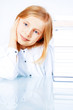 Photo: small smiling girl reading book in library small smiling girl reading book in library