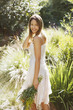 Smiling woman carrying bouquet of flowers outdoors