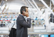 Businessman talking on cell phone in airport