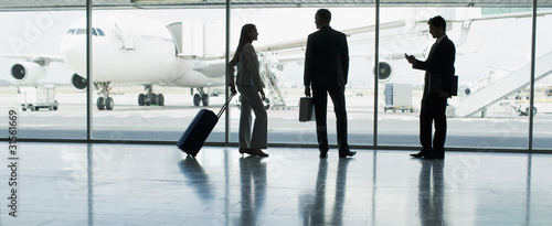 Photo: Businesspeople with suitcase in airport Businesspeople with suitcase in airport