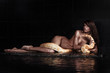 Beautiful woman lying with Python in water