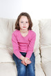 Brown haired girl sitting on Sofa
