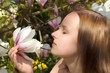 Frau riecht an einer Magnolie