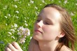 Frau riecht an einem Blumenstrauß