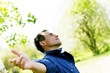 Photo: Satisfied smiling businessman standing in the green outdoors. Satisfied smiling businessman standing in the green outdoors.