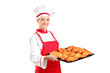 A female baker holding freshly baked croissants A female baker holding freshly baked croissants