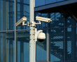 cctv cameras on front of modern glass building