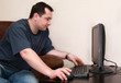 Photo: man works at computer at home man works at computer at home