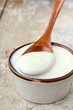 fresh natural yoghurt in a ceramic cup on wooden table
