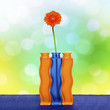 Orange gerbera flower in vase on spring background