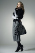 Photo: young fashion model posing in light background in the studio young fashion model posing in light background in the studio