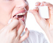 Foto: Young woman flossing teeth Young woman flossing teeth