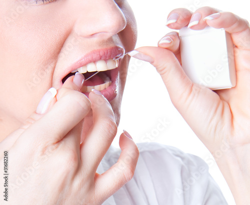 Photo: Young woman flossing teeth Young woman flossing teeth