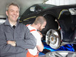 Master mechanic is happy with his job in a garage