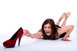 Beautiful young woman trying to reach her high heels