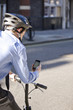 A businessman on his bicycle, looking at his mobile phone