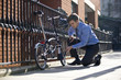 A businessman pumping up the tires on his bicycle