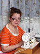 old woman sews clothes in-home