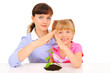 Mother and daughter protecting plant