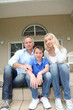 Portrait of family sitting on the front door stairs Portrait of family sitting on the front door stairs