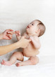 The happy baby playing with hands of mum