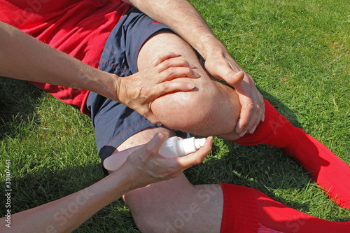 Photo: Therapist attending to injured sportsman Therapist attending to injured sportsman