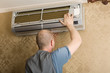technician installs a new air conditioner in the apartment