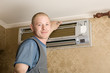 technician installs a new air conditioner in the apartment