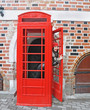 woman in red hat look out from phonebox woman in red hat look out from phonebox
