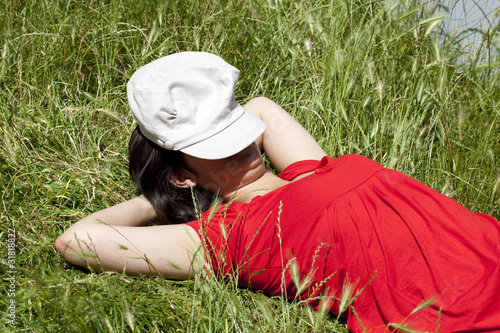 Photo: jeune femme au repos couchée dans l'herbe jeune femme au repos couchée dans l'herbe