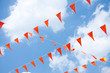 Orange hanging festive Dutch Flags against a blue sky