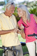 Happy Senior Couple Cycling Using GPS on Smart Phone