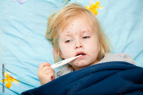 Photo: Sick cute girl is measuring the temperature Sick cute girl is measuring the temperature