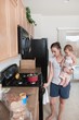 A Mother Cooking And Holding A Baby