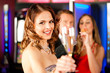 Drei Freunde mit Sekt in Bar oder Casino