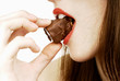 close up of woman's lips biting a chocolate bar